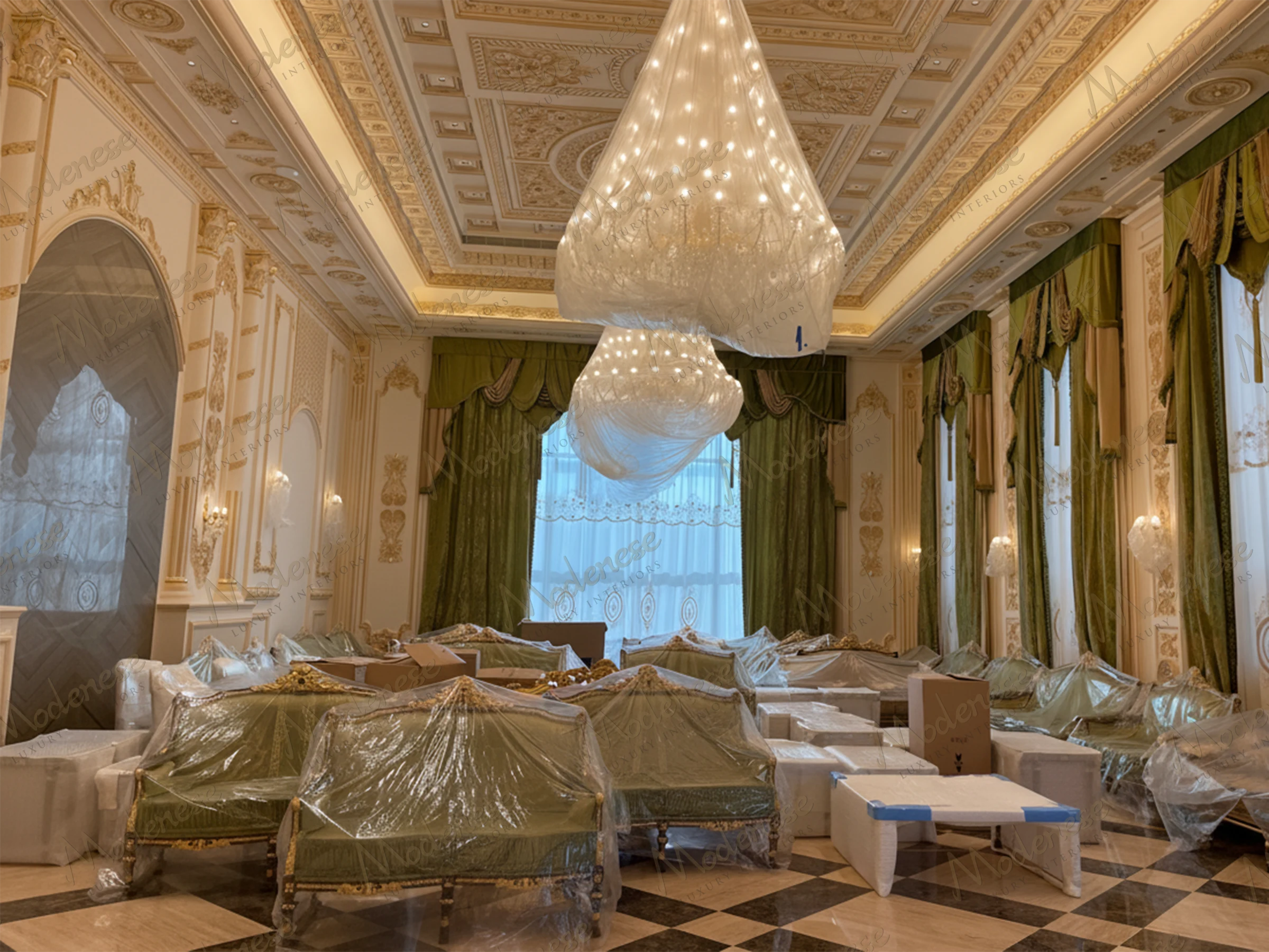 Ornate hall in Saudi Arabia King's Palace with green velvet sofas covered in plastic wrap, grand chandeliers wrapped for protection, and gilded wall moldings