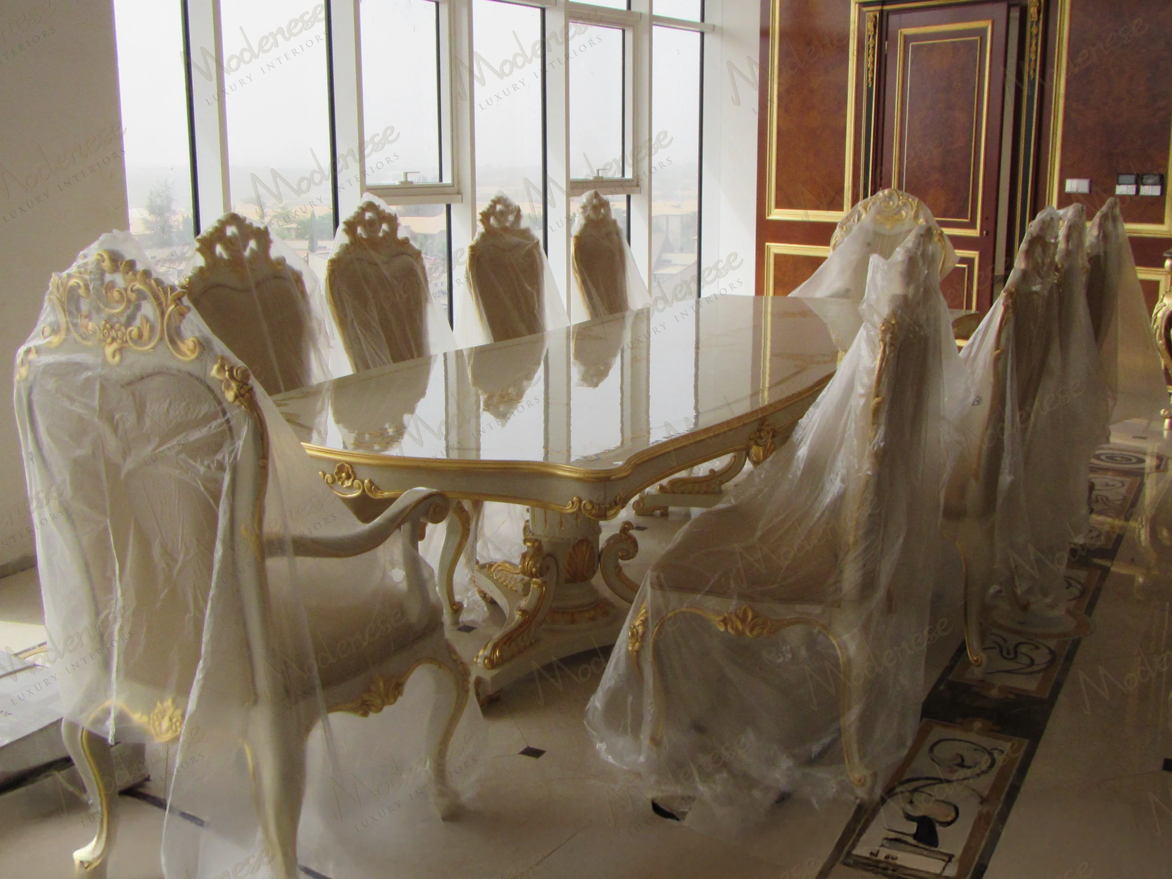 Turnkey interior fit out of a grand palace entrance hall with sweeping staircases, gilded moldings, and a massive crystal chandelier