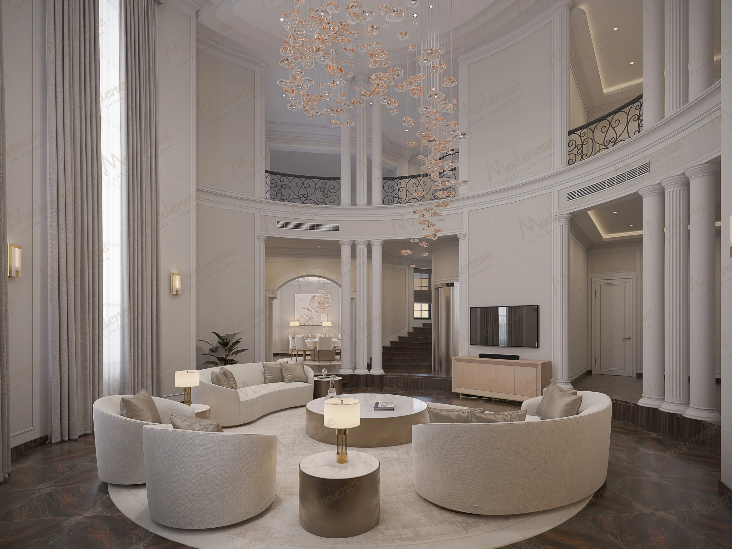 Contemporary Miami villa living room with curved beige seating, marble-top tables, dark wood flooring, and a dramatic cascading glass chandelier beneath a double-height ceiling with classical columns and iron balcony railings